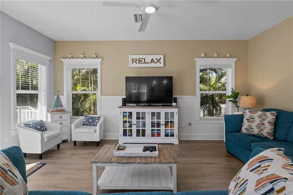 a living room with furniture and a dining table with kitchen view