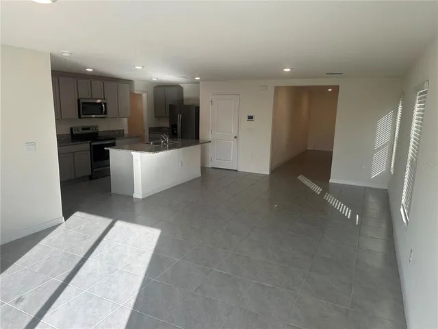 a kitchen with kitchen island granite countertop a stove sink and cabinets