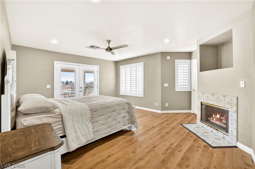 1135 Calico Ridge Drive Henderson, NV 89011 - Photo 32 of 86 A tranquil bedroom retreat features a cozy fireplace and convenient outdoor access.