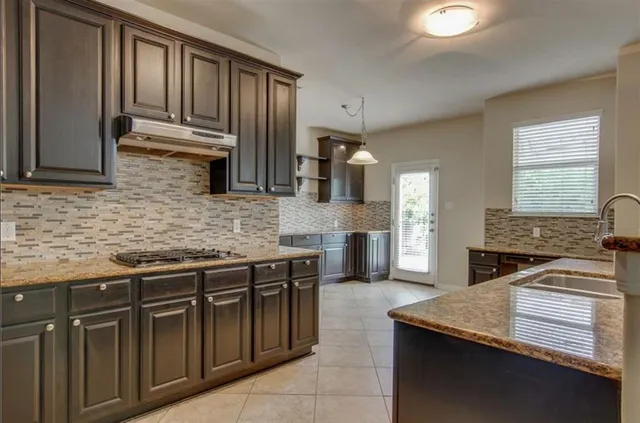 a kitchen with stainless steel appliances granite countertop a sink stove and cabinets