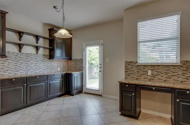 a kitchen with stainless steel appliances granite countertop cabinets a sink a island and windows