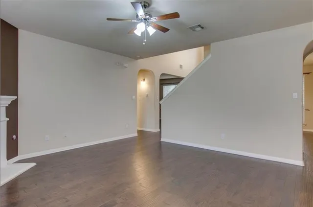 an empty room with a fan & a ceiling fan