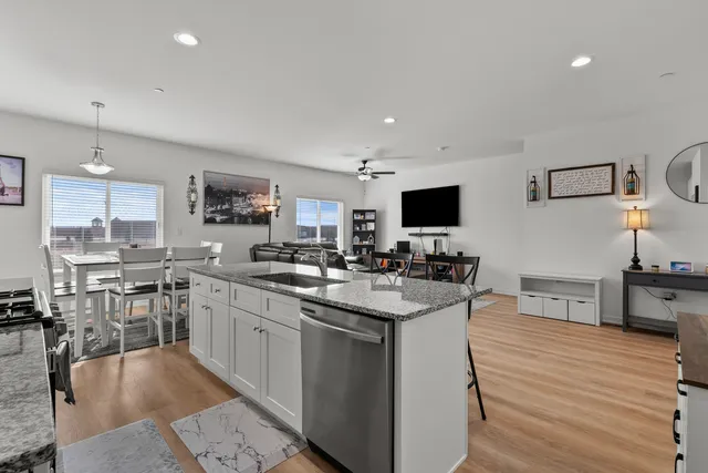 a kitchen with stainless steel appliances granite countertop a sink stove and cabinets