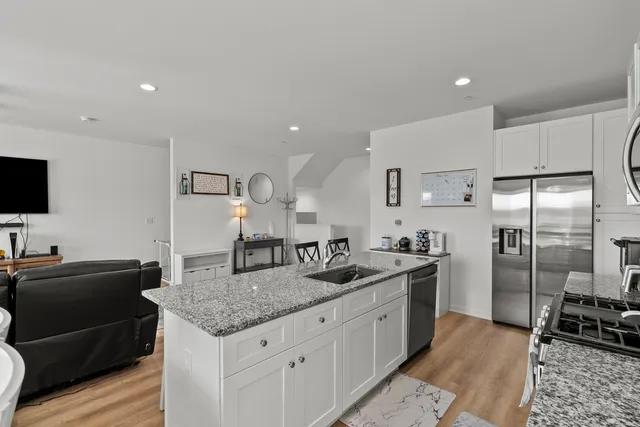 a kitchen with stainless steel appliances granite countertop a sink and a refrigerator