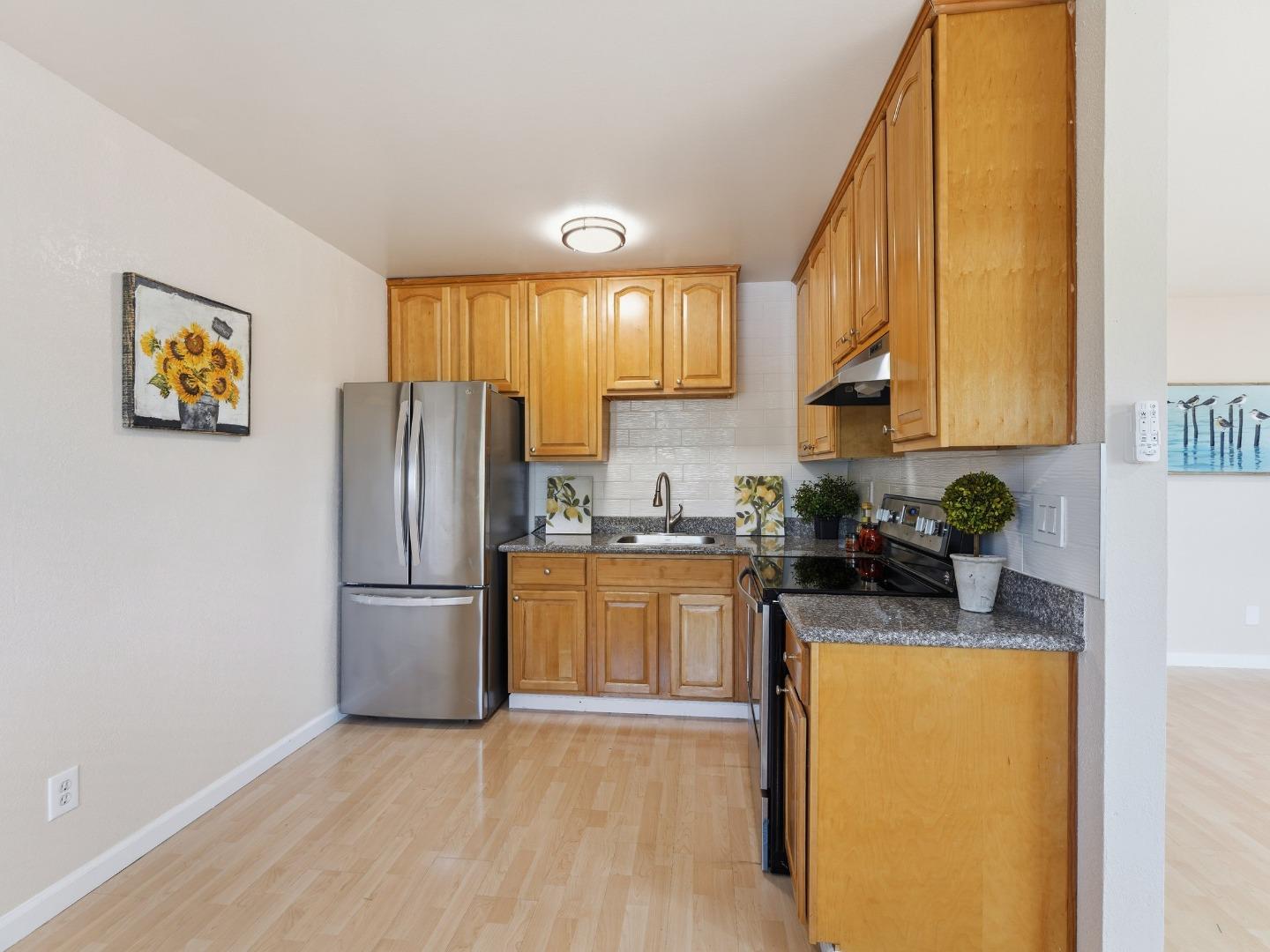 607 Valley Forge Way, Unit 4 Campbell, CA 95117 - Photo 5 of 12 a kitchen with granite countertop a refrigerator a sink a stove and cabinets