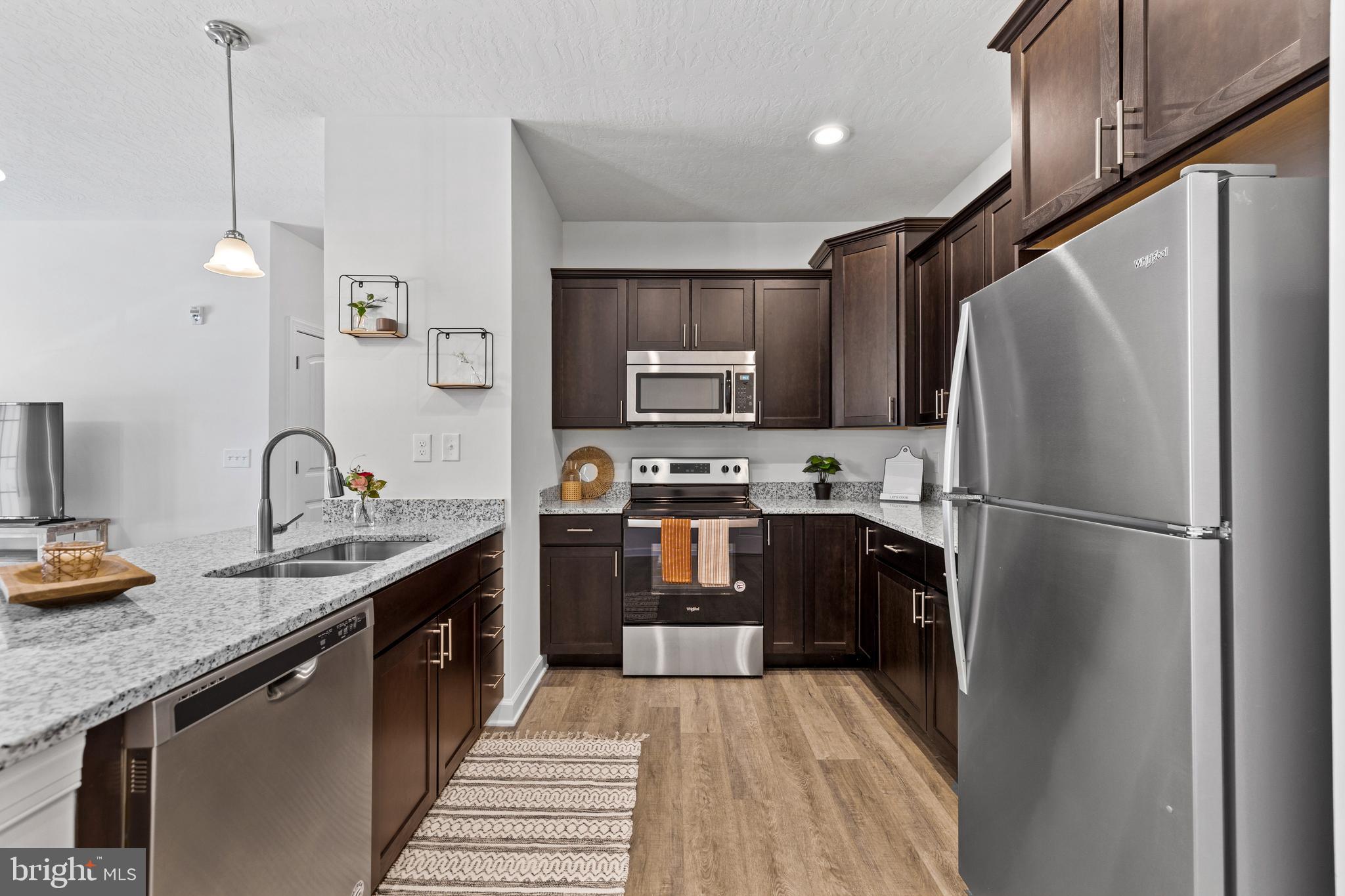 4307 Rowen Court York, PA 17403 - Photo 8 of 28 a kitchen with stainless steel appliances granite countertop a refrigerator a sink dishwasher a stove and a microwave