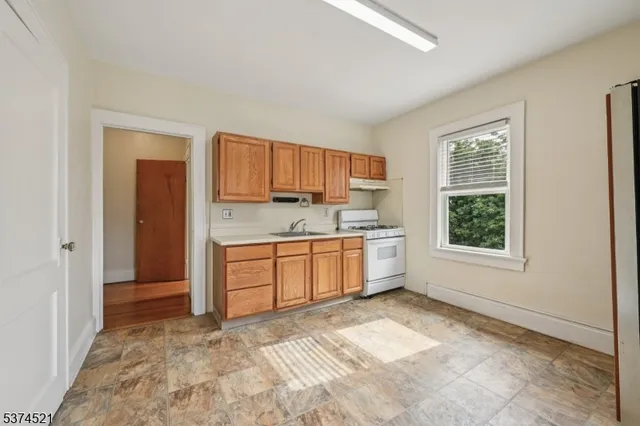 a view of a kitchen with a sink and dishwasher with wooden floor