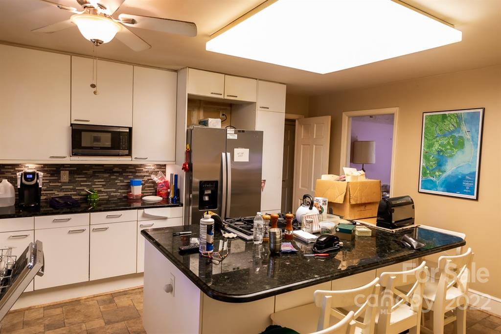 7300 Lancer Drive Charlotte, NC 28226 - Photo 37 of 48 a kitchen with kitchen island granite countertop a sink appliances and cabinets