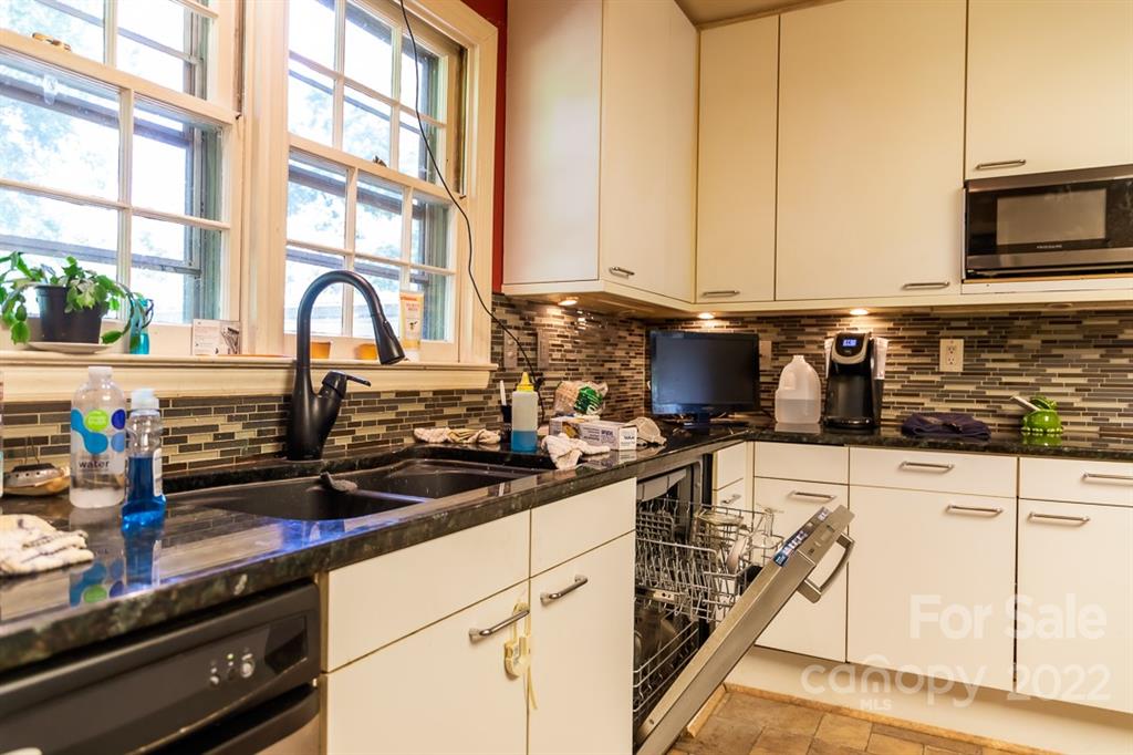 7300 Lancer Drive Charlotte, NC 28226 - Photo 38 of 48 a kitchen with stainless steel appliances a sink a stove and white cabinets next to a window
