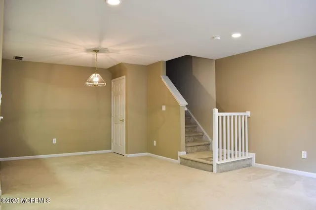 an empty room with a ceiling fan and stairs