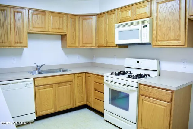 a kitchen with stainless steel appliances granite countertop white cabinets sink and a granite counter top