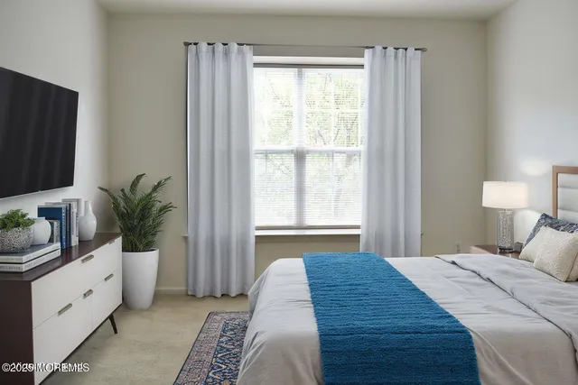 a bedroom with a large bed and a potted plant