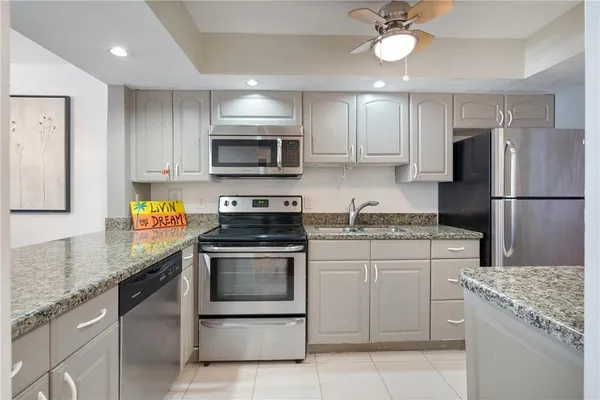 a kitchen with granite countertop cabinets stainless steel appliances and a counter space