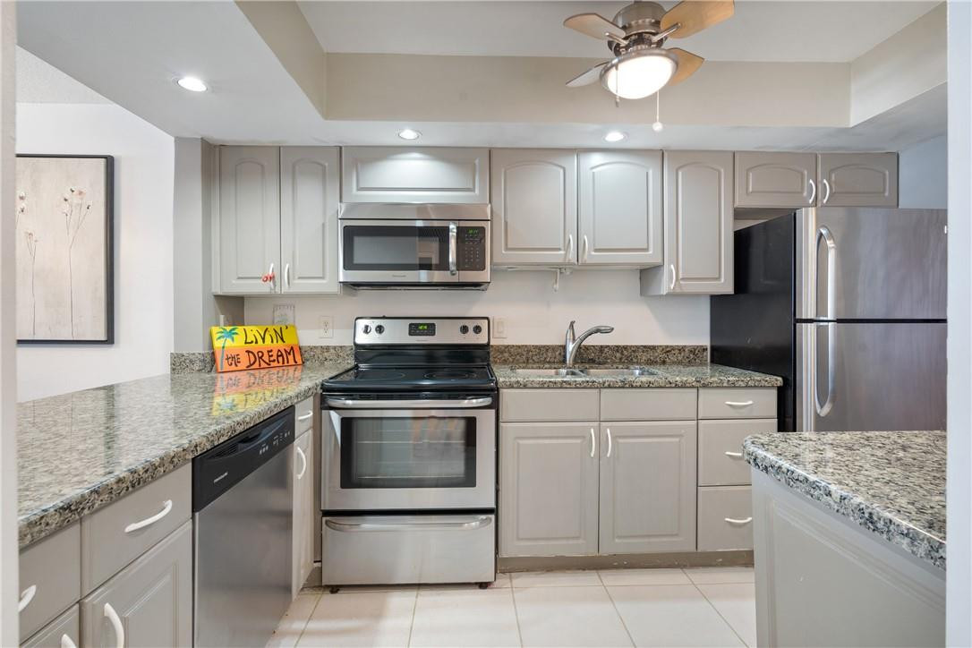 a kitchen with granite countertop cabinets stainless steel appliances and a counter space