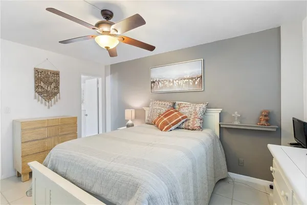 a bedroom with a large bed and a ceiling fan