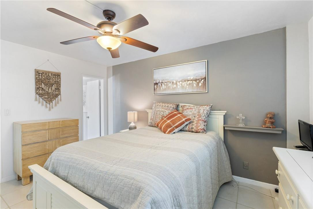 4500 North Federal Highway, Unit 150F Lighthouse Point, FL 33064 - Photo 12 of 18 a bedroom with a large bed and a ceiling fan