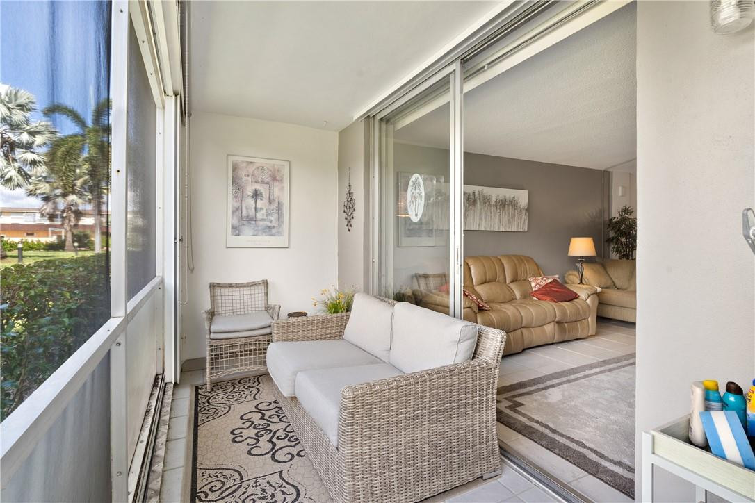 4500 North Federal Highway, Unit 150F Lighthouse Point, FL 33064 - Photo 15 of 18 a living room with furniture and a floor to ceiling window