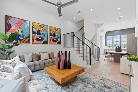 a living room with furniture stairs and a potted plant
