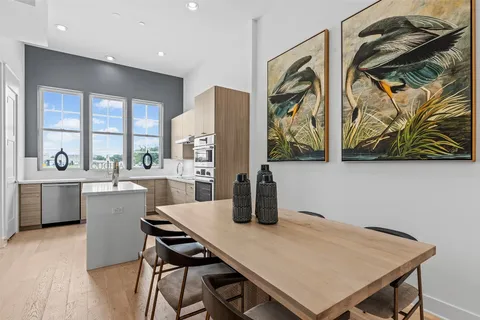 a kitchen with a table chairs and a wooden floor