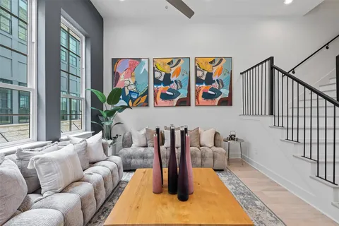 a living room with furniture stairs and a potted plant