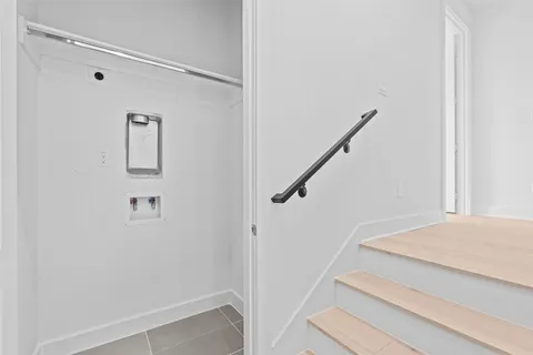 a view of staircase with white walls and railing