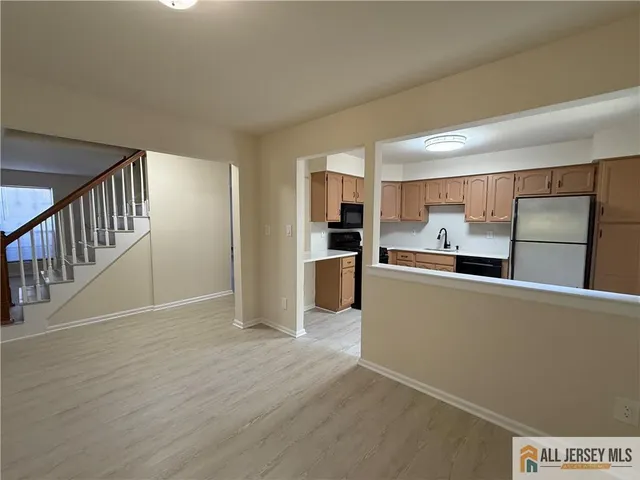 a living room with stainless steel appliances kitchen island granite countertop a refrigerator and a stove top oven
