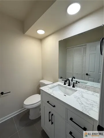 a bathroom with a granite countertop sink a toilet and a mirror