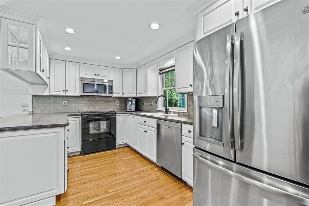21 Madison Road Wellesley, MA 02481 - Photo 13 of 26 a kitchen with kitchen island granite countertop stainless steel appliances cabinets a sink and a window