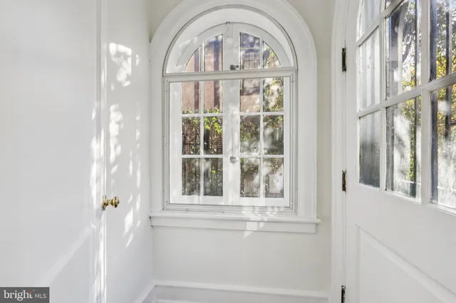 a living room with furniture a large window and wooden floor