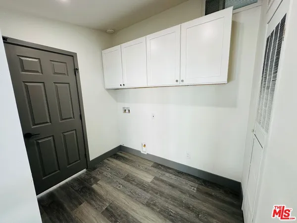 an empty room with wooden floor and entrance