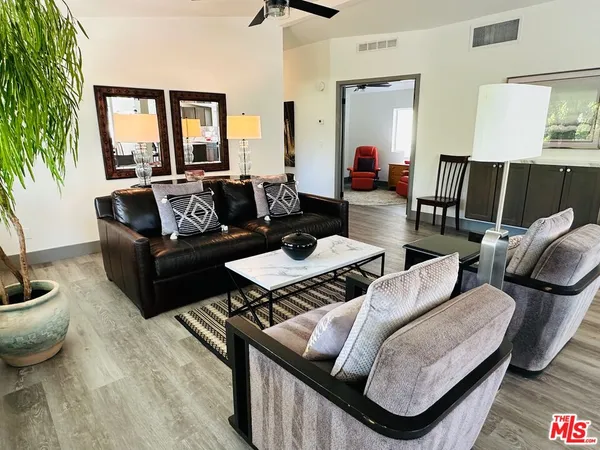 a living room with furniture and a wooden floor