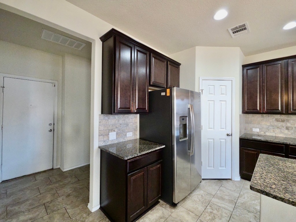 3805 Tranquil Lane Austin, TX 78728 - Photo 11 of 30 a kitchen with granite countertop a refrigerator and a sink