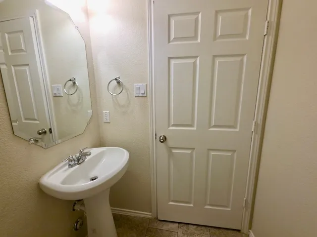 a bathroom with a sink a mirror a lamp and window