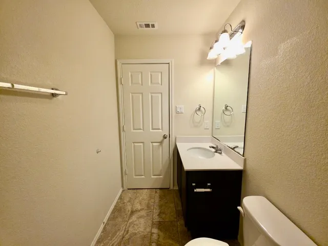a bathroom with a sink a toilet and mirror