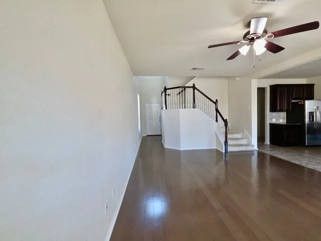 a view of a hallway with wooden floor and staircase