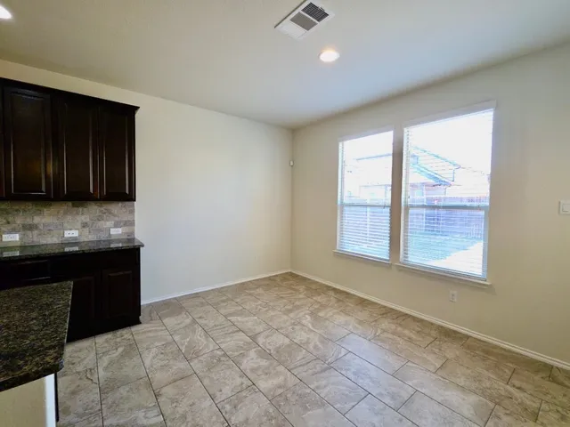 a view of an empty room with a kitchen
