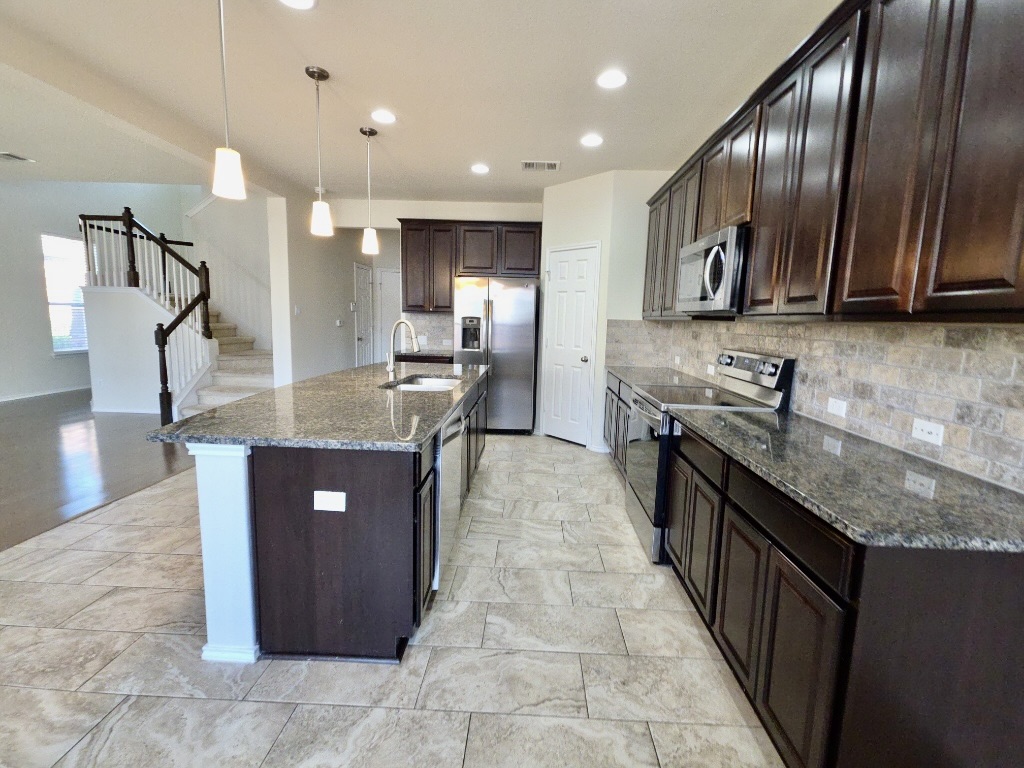 3805 Tranquil Lane Austin, TX 78728 - Photo 10 of 30 a kitchen with kitchen island granite countertop a sink counter top space appliances and cabinets