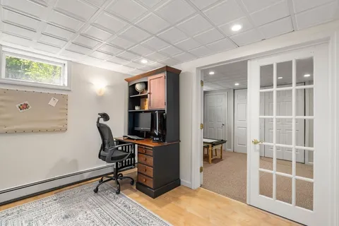 a view of a workspace with furniture and a window
