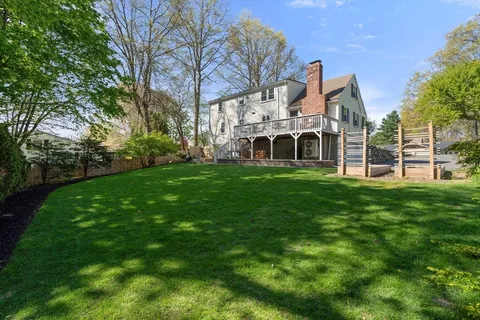 a front view of a house with a garden and trees