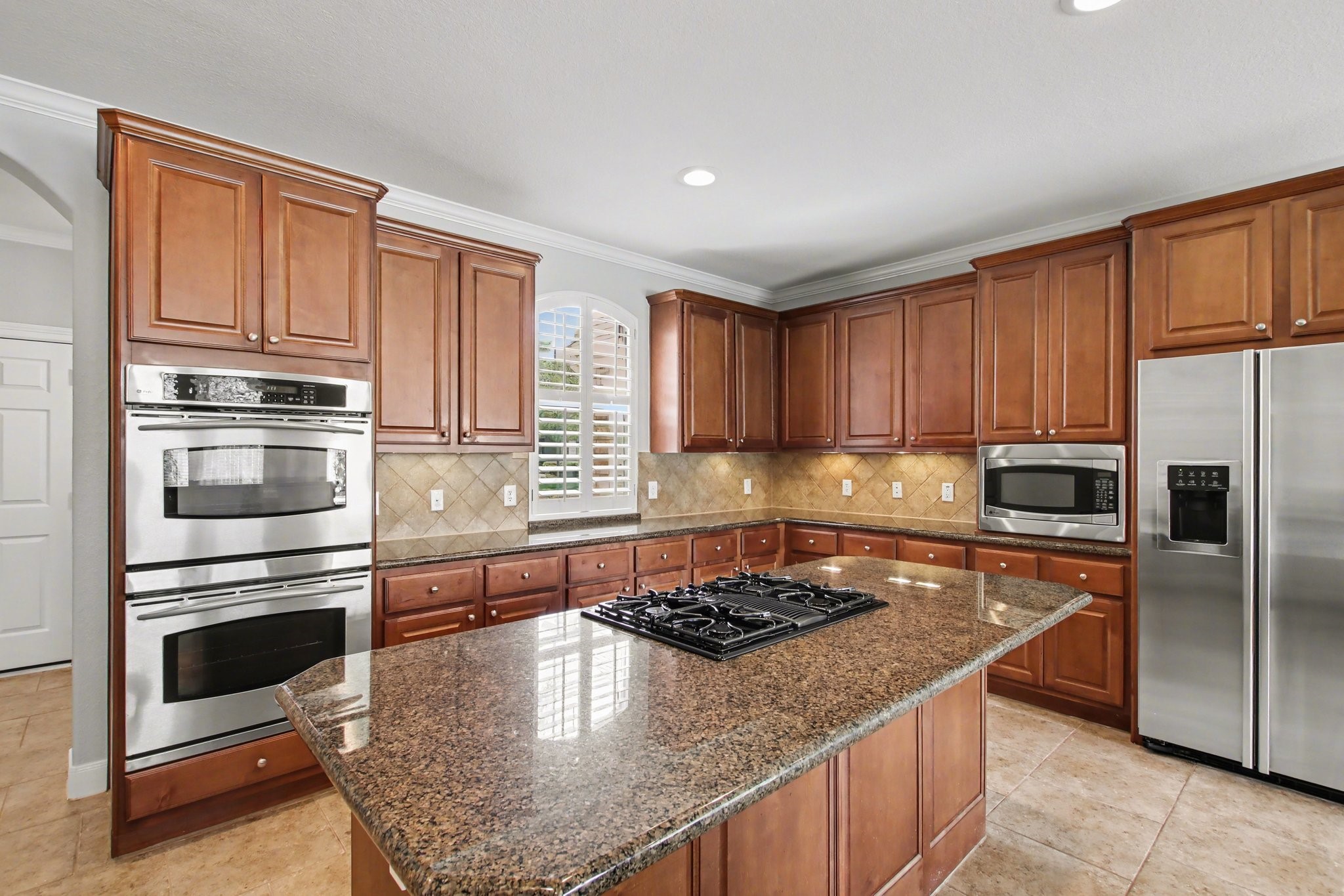 5115 Luke Ridge Lane Katy, TX 77494 - Photo 14 of 36 a kitchen with stainless steel appliances granite countertop a stove a refrigerator and a sink with wooden cabinets