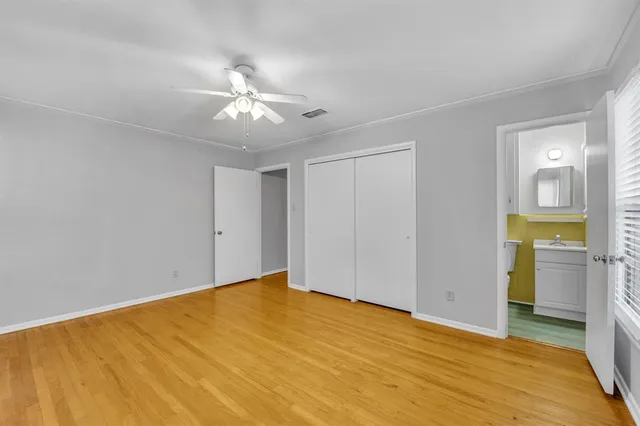a view of an empty room with closet and a window