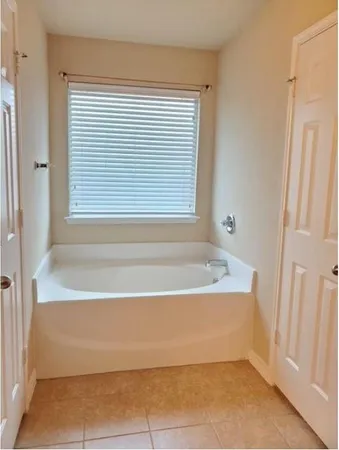 a bathroom with bathtub next to a window
