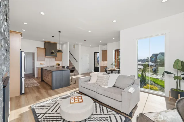 a living room with stainless steel appliances kitchen island granite countertop a couch and a view of kitchen