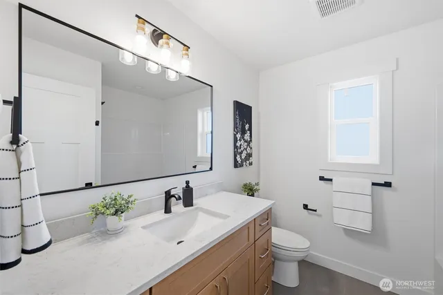 a bathroom with a sink a toilet and mirror