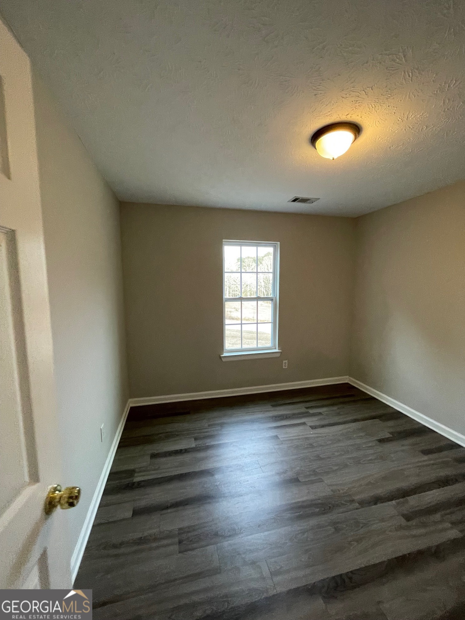 42 Pope Road Villa Rica, GA 30180 - Photo 13 of 14 an empty room with wooden floor and windows