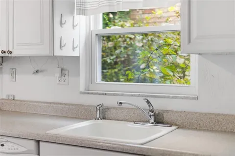 a bathroom with a granite countertop sink and a window