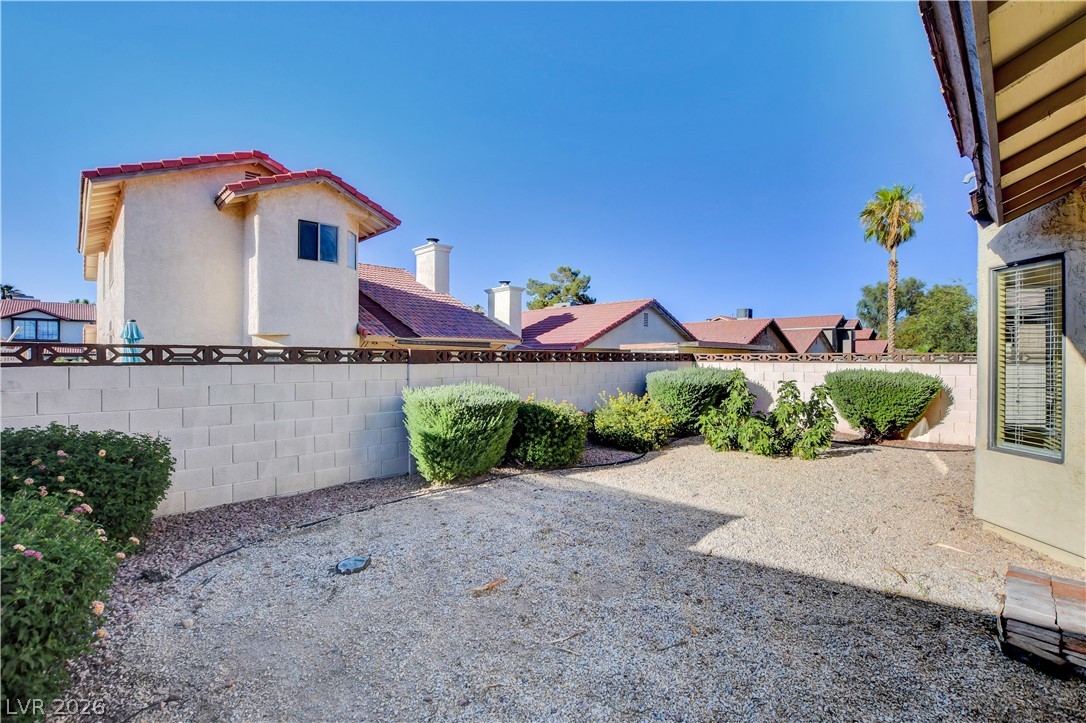 6440 Hartwood Road Las Vegas, NV 89108 - Photo 53 of 59 A private desert-scaped backyard with lush greenery and a sturdy block wall.