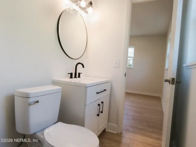 a bathroom with a toilet a sink and a mirror