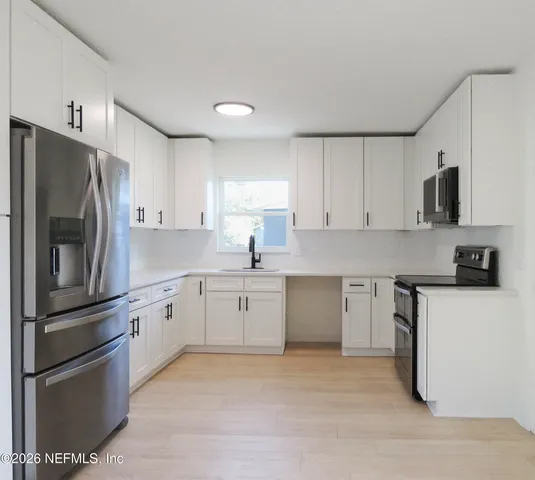 a kitchen with stainless steel appliances granite countertop a refrigerator sink and stove