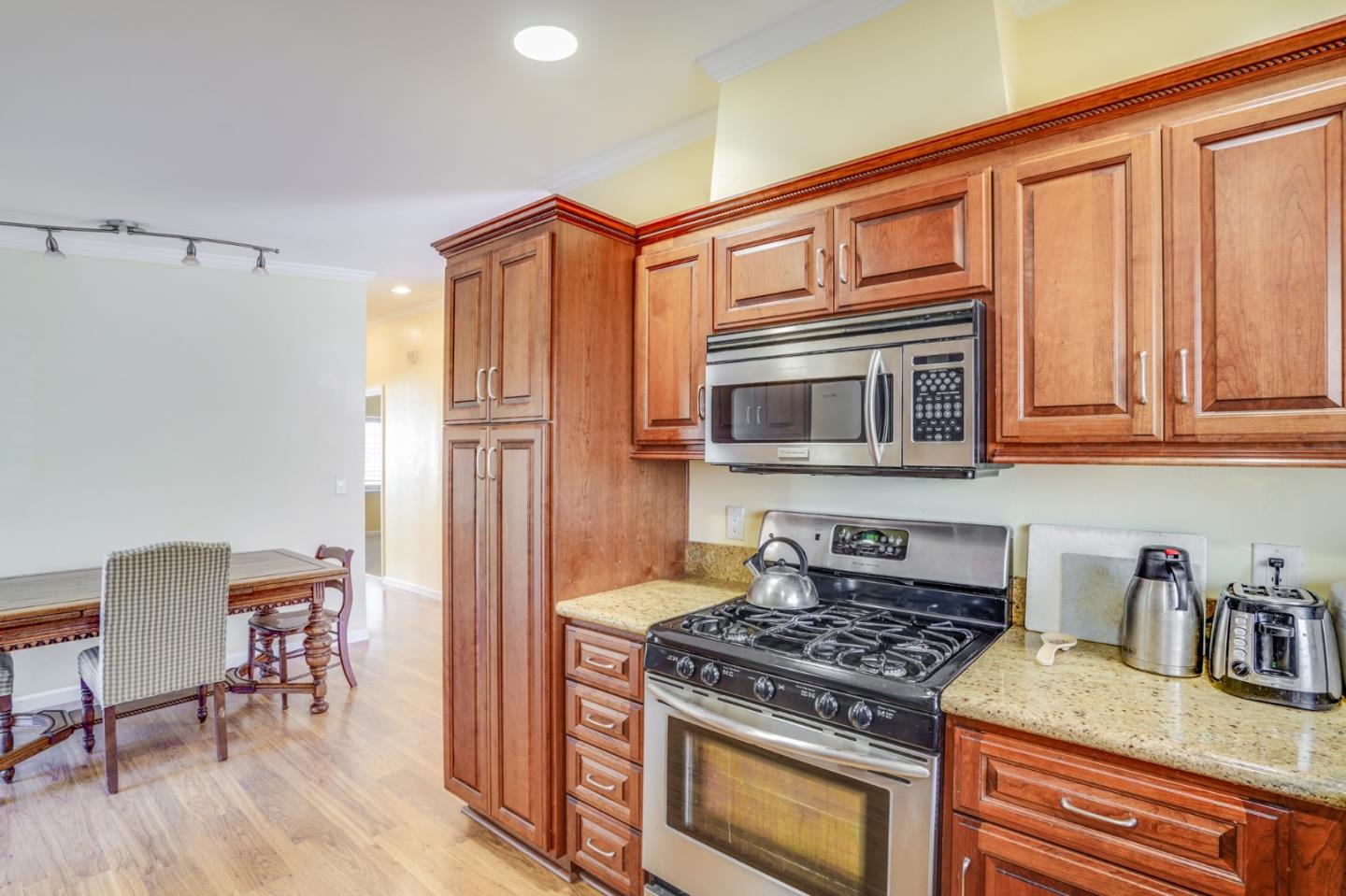 1630 Cross Way San Jose, CA 95125 - Photo 13 of 52 a kitchen with stainless steel appliances granite countertop a stove top oven a refrigerator and a dining table with wooden floor
